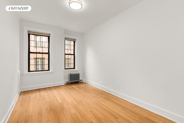 6 Burns St Unit 220, New York City, NY 11375 - empty room featuring radiator heating unit and light wood-type flooring