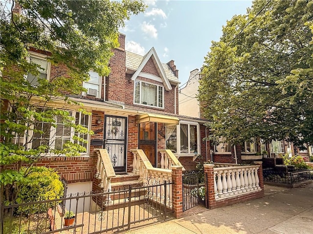 7007 Narrows Ave, New York City, NY 11209 - tudor-style house featuring a fenced front yard, brick siding, a chimney, and a gate