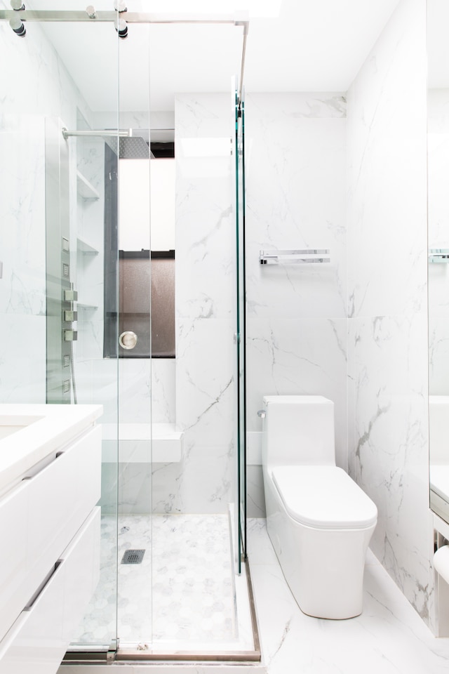 32 Jones St Unit 2D, New York City, NY 10014 - full bathroom with vanity, a marble finish shower, and marble tiled floors