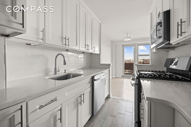 135 Ocean Pkwy Unit 9M, New York City, NY 11218 - kitchen with appliances with stainless steel finishes, decorative backsplash, white cabinetry, and light wood-style flooring