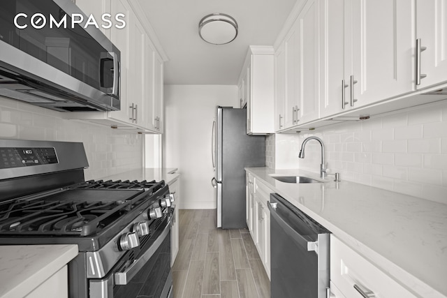 135 Ocean Pkwy Unit 9M, New York City, NY 11218 - kitchen featuring stainless steel appliances, white cabinetry, decorative backsplash, light stone counters, and wood finish floors