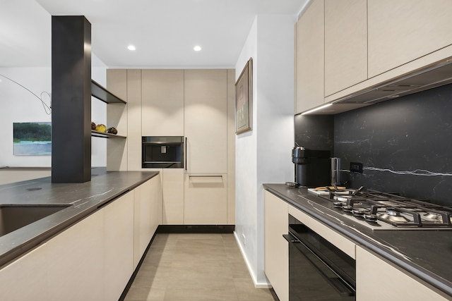 15 W 53rd St Unit 20E, New York City, NY 10019 - kitchen featuring oven, tasteful backsplash, dark countertops, cream cabinetry, and recessed lighting