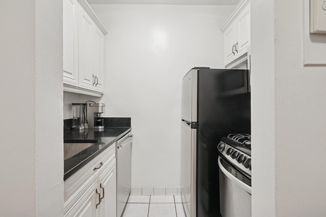 320 E 35th St Unit 2H, New York City, NY 10016 - kitchen featuring appliances with stainless steel finishes, white cabinetry, light tile patterned flooring, and dark stone counters