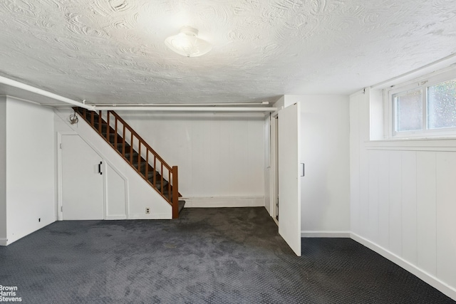 31-28 56th St, New York City, NY 11377 - below grade area featuring dark carpet, a textured ceiling, and stairway