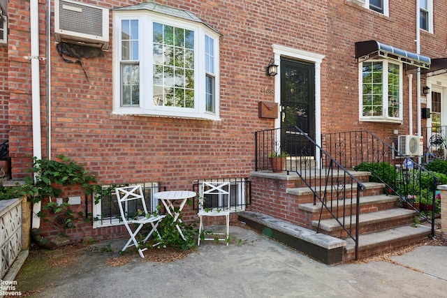 31-28 56th St, New York City, NY 11377 - view of exterior entry with brick siding and a wall mounted AC