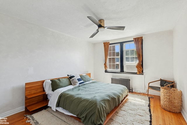 31-28 56th St, New York City, NY 11377 - bedroom featuring radiator, wood finished floors, and ceiling fan