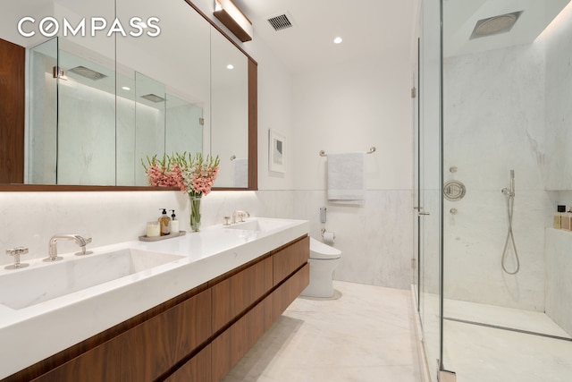 515 Park Ave Unit 6A, New York City, NY 10022 - bathroom with a marble finish shower, double vanity, tile walls, wainscoting, and marble finish flooring