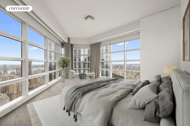 146 W 57th St Pha, Pha, New York City, NY 10019 - bedroom featuring multiple windows, wood-type flooring, and a view of city