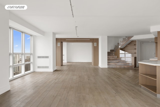 146 W 57th St Pha, Pha, New York City, NY 10019 - unfurnished living room featuring wood-type flooring and stairs