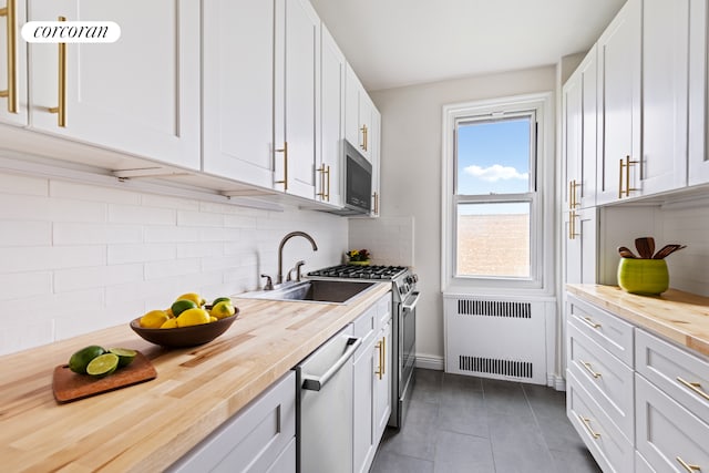 125 Ocean Ave Unit 6F, New York City, NY 11225 - kitchen with wood counters, stainless steel appliances, radiator, and white cabinets