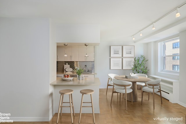 63 E 9th St Unit 9G, New York City, NY 10003 - dining area featuring baseboards and track lighting