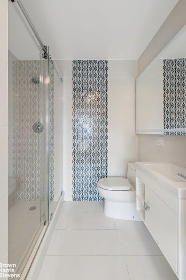 330 3rd Ave Unit 15E, New York City, NY 10010 - full bath featuring vanity, a shower stall, tile patterned flooring, and tile walls