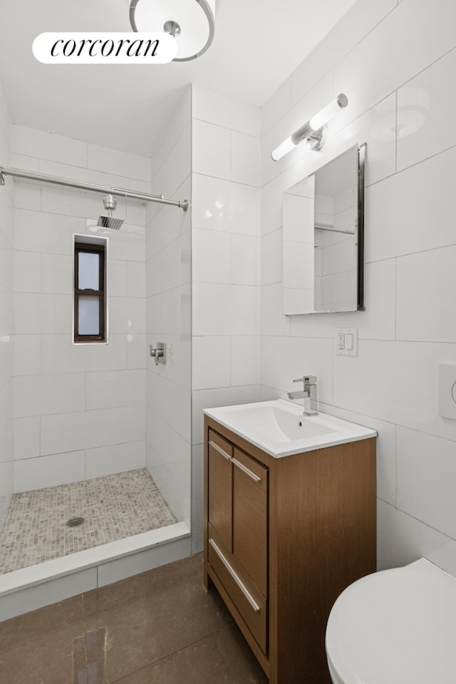308 W 30th St Unit 1A, New York City, NY 10001 - bathroom featuring vanity, a tile shower, and tile walls