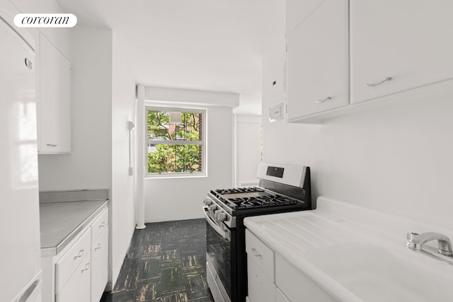 80 La Salle St Unit 6D, New York City, NY 10027 - kitchen with stainless steel gas stove, light countertops, white cabinets, and dark flooring