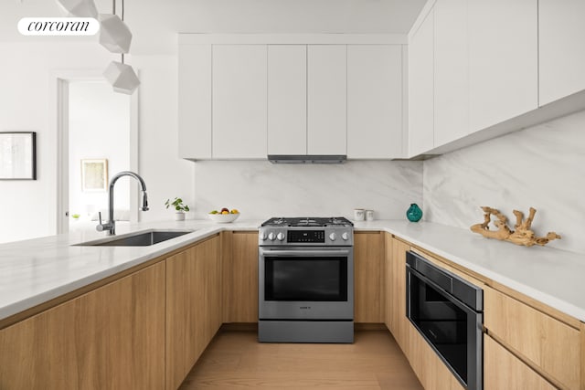 184 Hawthorne St Unit 4B, New York City, NY 11225 - kitchen with stainless steel range with gas stovetop, built in microwave, modern cabinets, white cabinets, and light wood-style floors