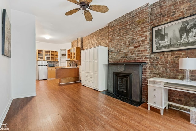 433 W 46th St Unit 1Rw, New York City, NY 10036 - unfurnished living room with wood finished floors, a ceiling fan, and a fireplace with flush hearth