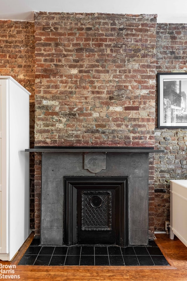 433 W 46th St Unit 1Rw, New York City, NY 10036 - detailed view of a large fireplace, wood finished floors, and brick wall