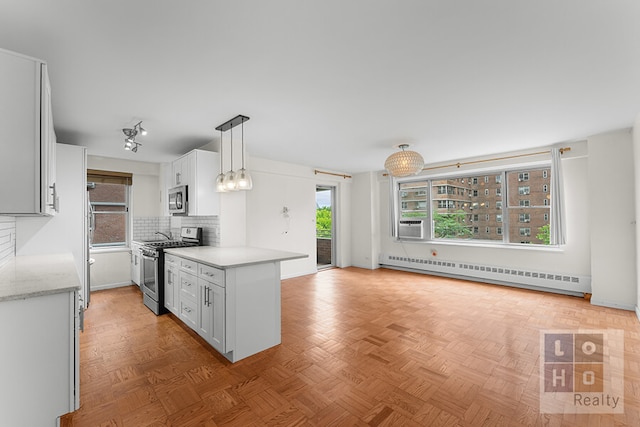 457 Fdr Dr Unit A604, New York City, NY 10002 - kitchen featuring appliances with stainless steel finishes, a baseboard heating unit, backsplash, white cabinets, and decorative light fixtures