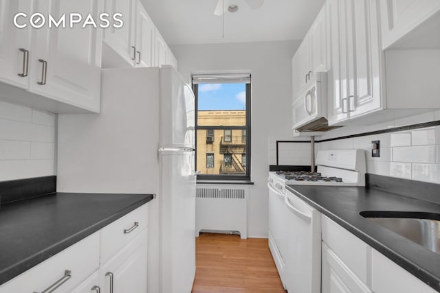 200 Pinehurst Ave Unit 5C, New York City, NY 10033 - kitchen featuring radiator heating unit, white appliances, dark countertops, and decorative backsplash