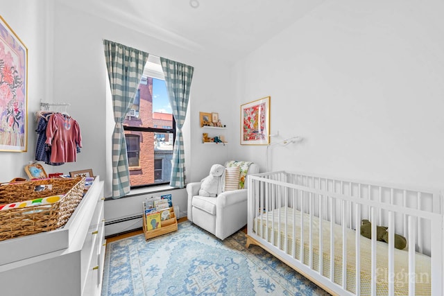 11 Sterling Pl Unit 4A, New York City, NY 11217 - bedroom with a nursery area, baseboard heating, and wood finished floors