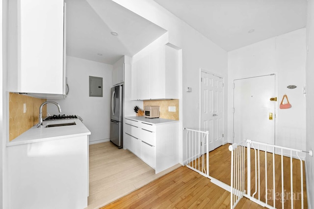 11 Sterling Pl Unit 4A, New York City, NY 11217 - kitchen with light countertops, light wood-style flooring, white cabinets, and freestanding refrigerator
