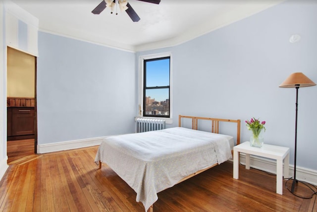 110 Cambridge Pl Unit 5-B, New York City, NY 11238 - bedroom with radiator heating unit, wood-type flooring, crown molding, and a ceiling fan