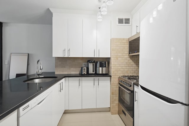 322 W 57th St Unit 18J, New York City, NY 10019 - kitchen featuring appliances with stainless steel finishes, white cabinetry, decorative backsplash, light tile patterned floors, and dark countertops