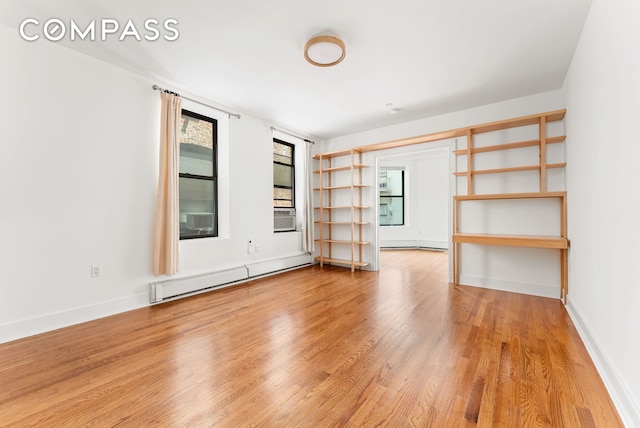 305 W 150th St Unit 511, New York City, NY 10039 - spare room featuring a baseboard heating unit and light wood finished floors