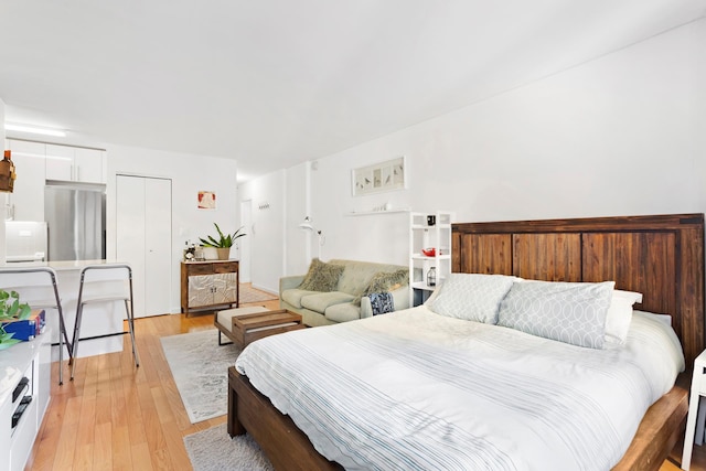 240 E 76th St Unit 3W, New York City, NY 10021 - bedroom featuring freestanding refrigerator, light wood-style flooring, and a closet
