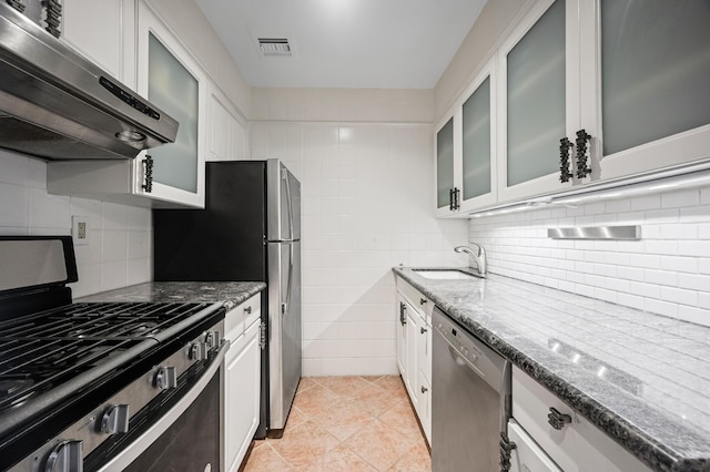250 W 15th St Unit 6F, New York City, NY 10011 - kitchen with ventilation hood, appliances with stainless steel finishes, dark stone counters, and light tile patterned floors