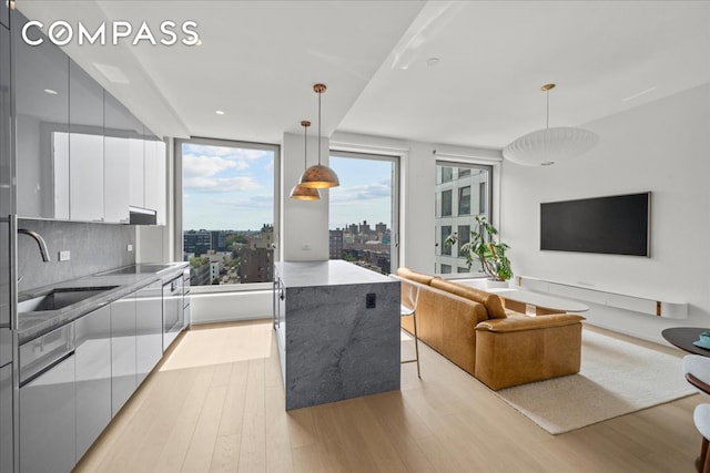 8 S 4th St Unit 15D, New York City, NY 11249 - kitchen with modern cabinets, white cabinetry, light wood finished floors, black electric stovetop, and recessed lighting