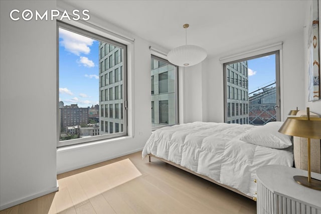 8 S 4th St Unit 15D, New York City, NY 11249 - bedroom with wood finished floors and a city view