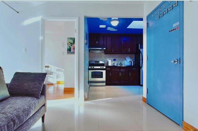 53-10 90th St Unit 4-B, New York City, NY 11373 - kitchen with stainless steel range, ventilation hood, decorative backsplash, and light tile patterned floors