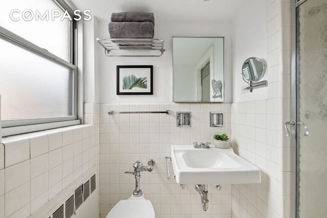70 E 10th St Unit 15R, New York City, NY 10003 - bathroom featuring tile walls, healthy amount of natural light, a stall shower, and radiator