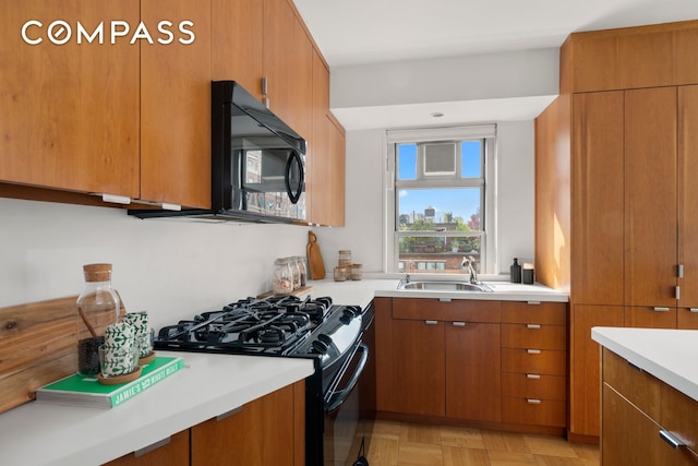 70 E 10th St Unit 15R, New York City, NY 10003 - kitchen featuring black appliances, brown cabinetry, and light countertops