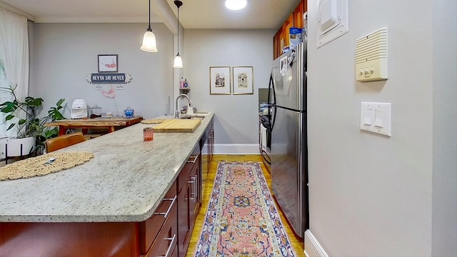 125 Washington Ave, New York City, NY 11205 - kitchen featuring light wood-style flooring, freestanding refrigerator, decorative light fixtures, reddish brown cabinets, and light stone countertops
