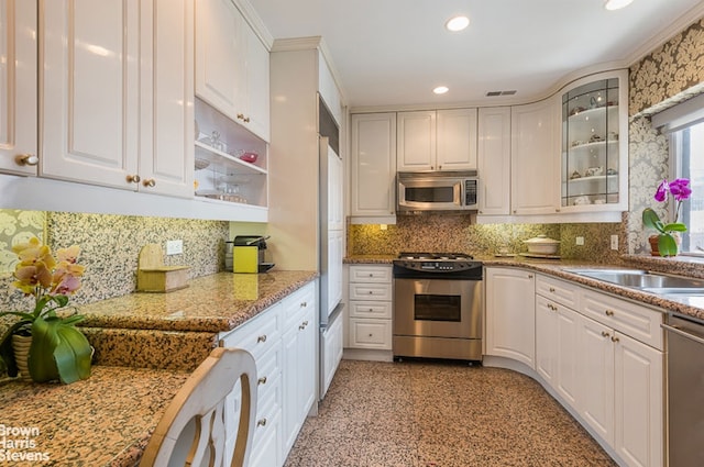 425 E 58th St Unit 22G, New York City, NY 10022 - kitchen featuring stainless steel appliances, white cabinets, glass insert cabinets, tasteful backsplash, and recessed lighting