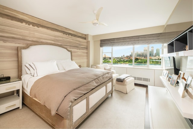 12 Beekman Pl Unit 11B, New York City, NY 10022 - bedroom featuring a view of city, wooden walls, a ceiling fan, and radiator