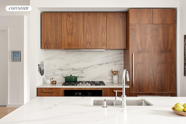 509 Pacific St Unit 4J, New York City, NY 11217 - kitchen featuring stainless steel gas stovetop, brown cabinets, backsplash, modern cabinets, and light stone countertops