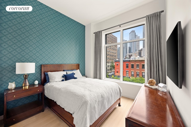 509 Pacific St Unit 4J, New York City, NY 11217 - bedroom featuring wallpapered walls, light wood-style flooring, and an accent wall
