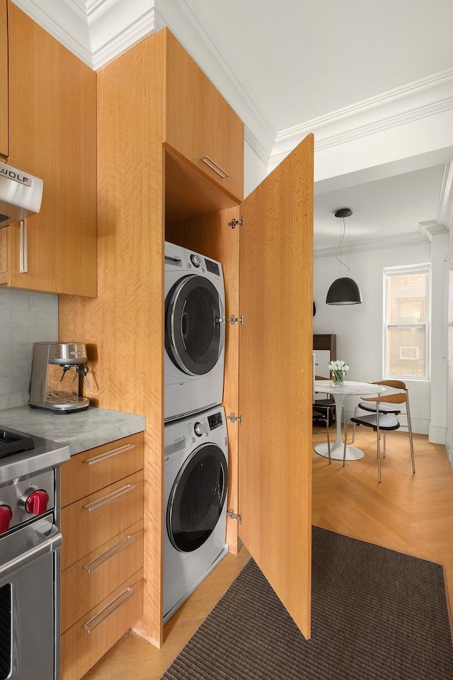 140 W 10th St Unit 3R, New York City, NY 10014 - washroom featuring stacked washer and clothes dryer and crown molding