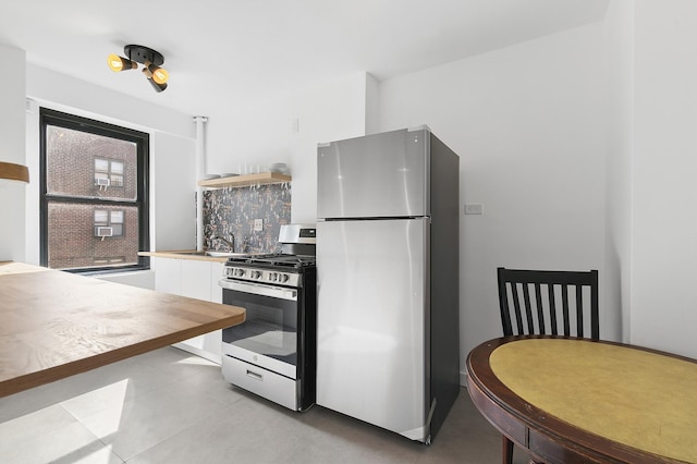 266 E Broadway Unit B-1902, New York City, NY 10002 - kitchen with appliances with stainless steel finishes, white cabinets, open shelves, and tasteful backsplash