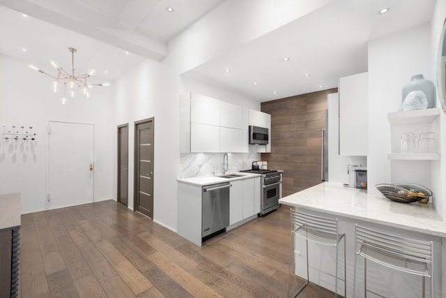 21 E 22nd St Unit 2B, New York City, NY 10010 - kitchen with stainless steel appliances, white cabinets, modern cabinets, dark wood-type flooring, and backsplash