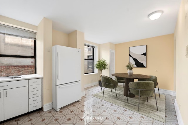 41 W 82nd St Unit 6-A, New York City, NY 10024 - kitchen with freestanding refrigerator, plenty of natural light, light countertops, and white cabinets