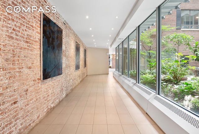 250 Mercer St Unit C302, New York City, NY 10012 - corridor featuring brick wall, recessed lighting, and light tile patterned flooring