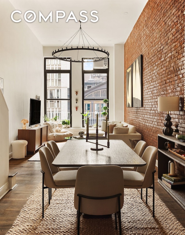 250 Mercer St Unit C302, New York City, NY 10012 - dining room featuring a chandelier, brick wall, and wood finished floors