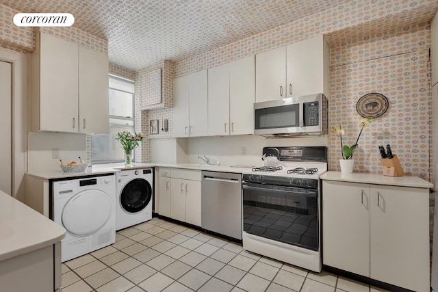 390 Riverside Dr Unit 11E, New York City, NY 10025 - kitchen with appliances with stainless steel finishes, washer / clothes dryer, light countertops, and light tile patterned floors