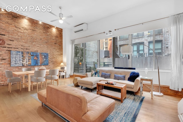 41 E 19th St Unit 1B, New York City, NY 10003 - living room featuring an AC wall unit, wood finished floors, ceiling fan, and brick wall