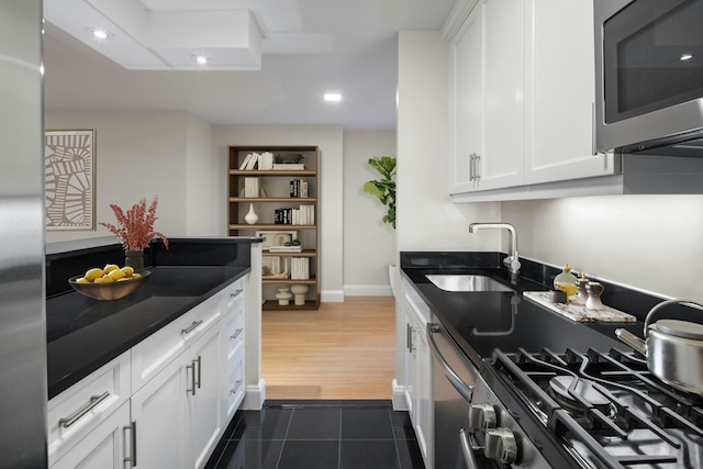 155 W 68th St Unit 35A, New York City, NY 10023 - kitchen featuring stainless steel microwave, white cabinetry, dishwashing machine, dark tile patterned flooring, and recessed lighting
