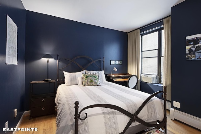 184 E 2nd St Unit 4G, New York City, NY 10009 - bedroom with wood finished floors, baseboard heating, and cooling unit
